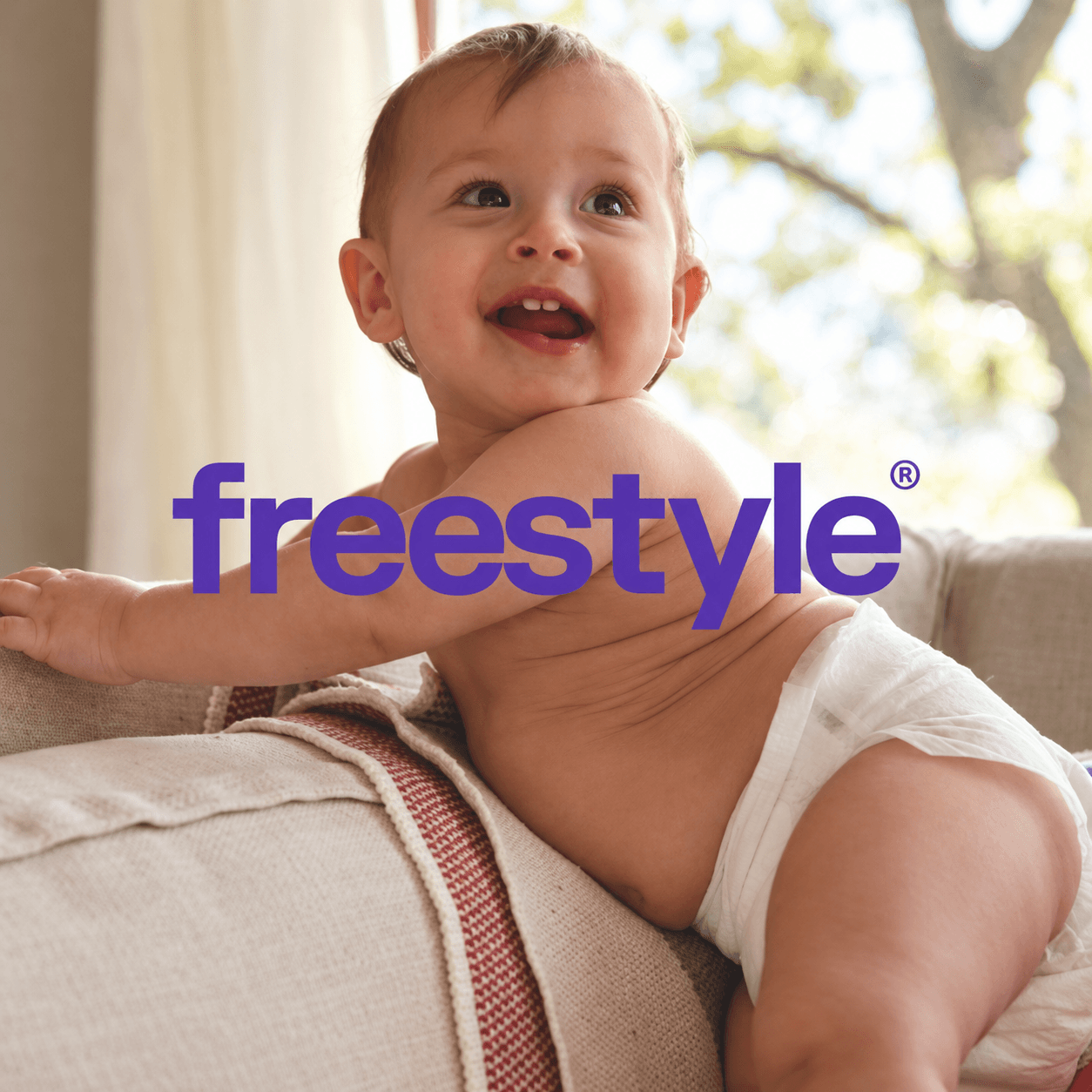 A smiling baby with the purple Freestyle wordmark